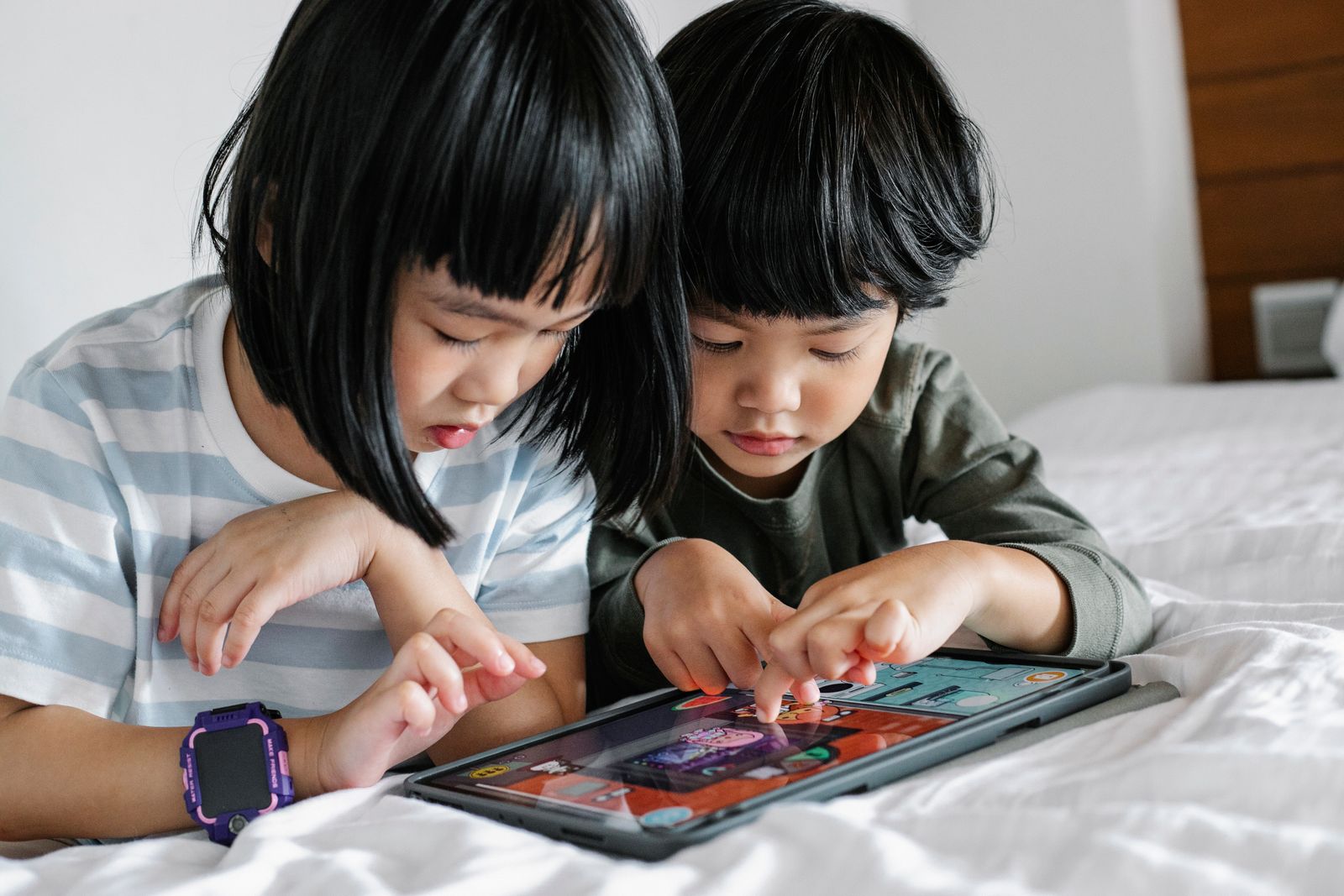 Two children reading together on a tablet